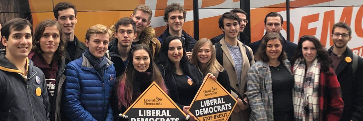 UCL Lib Dem members at a campaign event for the 2019 GE, holding orange Lib Dem "diamonds". 