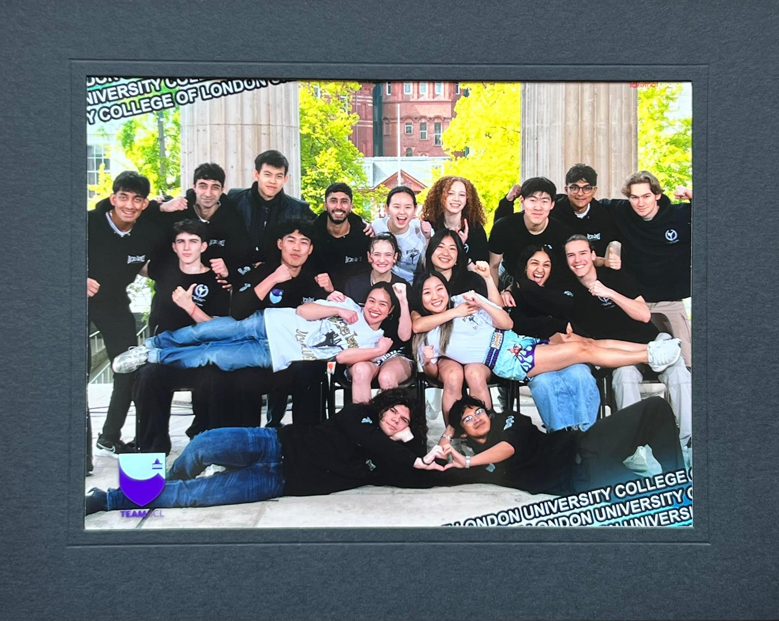 Group photo with two guys laying on the ground forming a heart , two girls laying across the first row of people