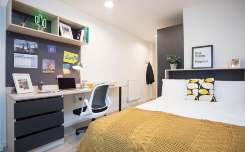room with double bed, desk, chair and storage space