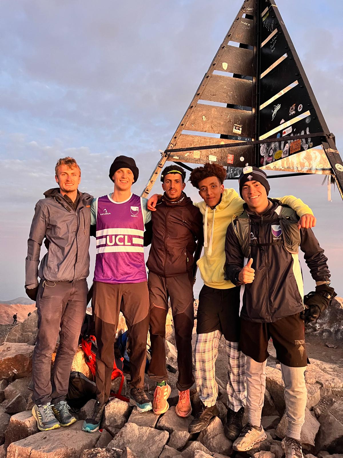 UCL RAX autumn running tour to the atlas mountains in Morocco. Runners pose on Mount Toubkal.