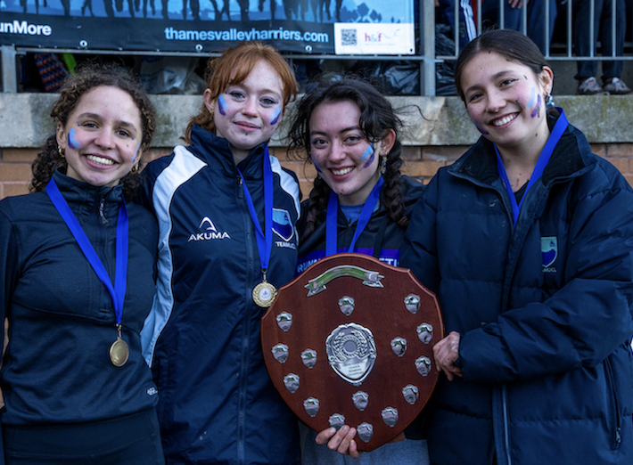 Four runners from the UCL RAX women's cross country accept the women's A team trophy.