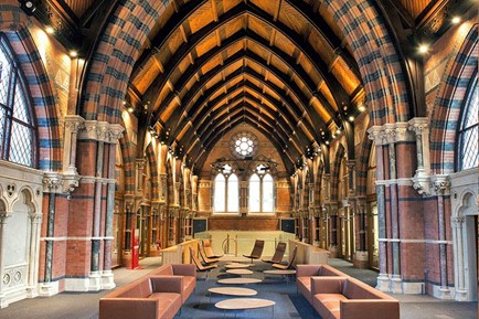 Sofas and round tables within a bright space with ecclesiastical architecture