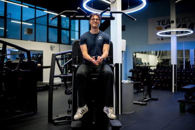 Man sitting on a gym machine smiling