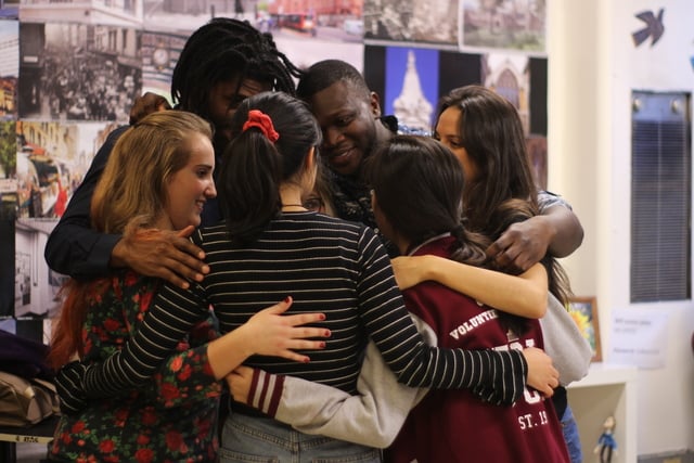DanceIt SLP volunteers in a group hug representing community and partnership in volunteering
