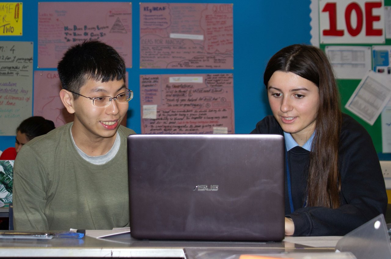 UCL student and young person looking at a laptop screen